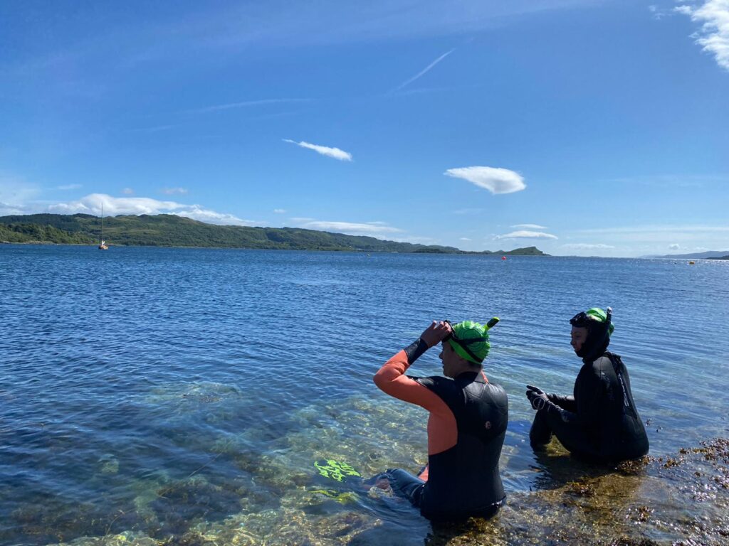 Two snorkellers sitting in the shallow water of Asknish Bay