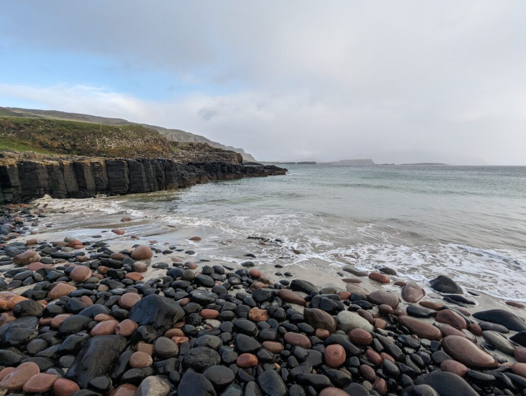 Pebble beach and rock formations of Tarbert Bay, Isle of Canna